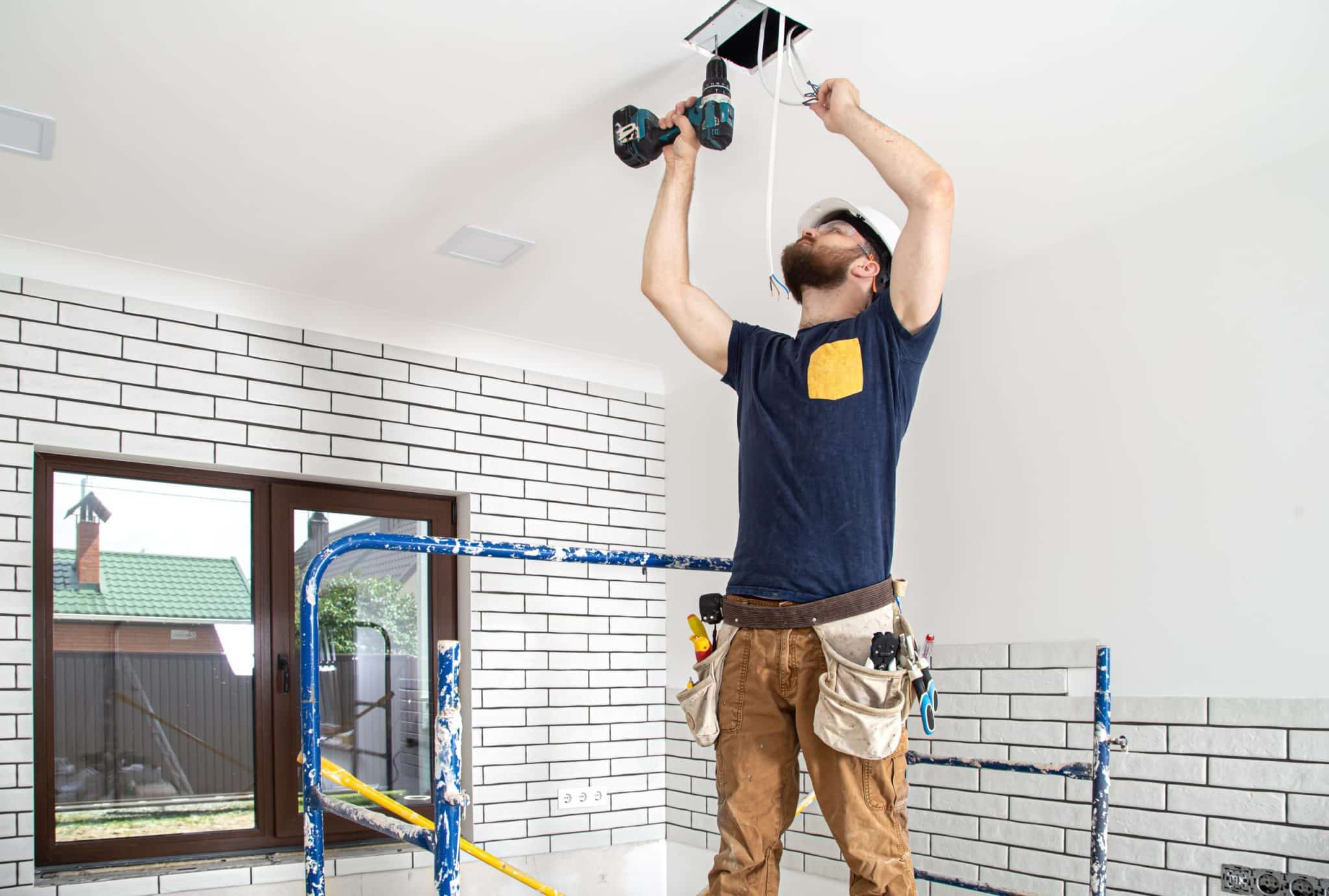 Electricista instalando un punto de luz en el techo de una vivienda